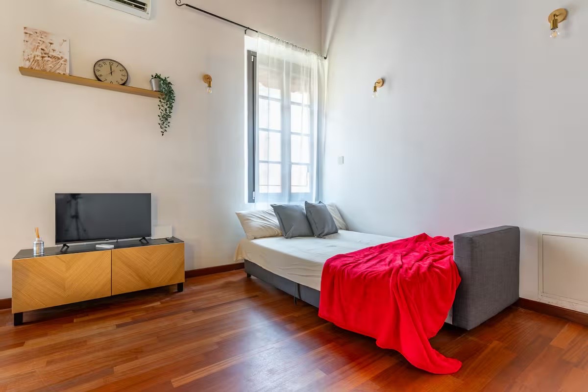 Divano letto aperto in un bilocale arredato per affitti brevi