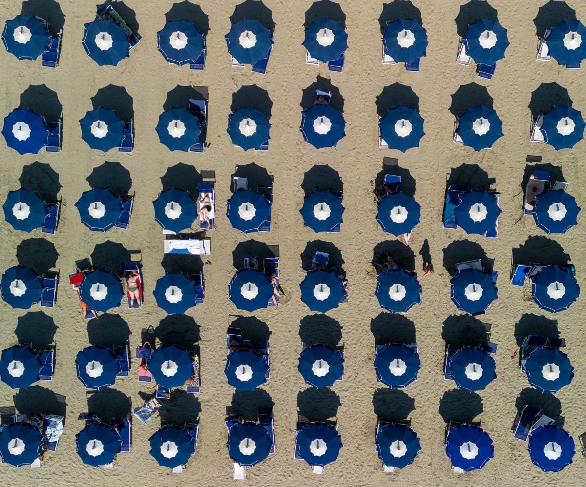 Ombrelloni blu su una spiaggia adriatica vista dall’alto